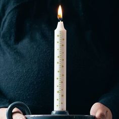 a person holding a mug with a lit candle in it