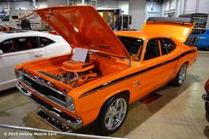 an orange muscle car with its hood open