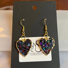 Step into a world of enchantment with our Sparkling Dreams earrings, featuring charming hearts adorned with dazzling glitter in various colors. Each pair is a celebration of individuality, allowing you to express your style with a burst of color and sparkle. Handcrafted with precision, these earrings are versatile enough to complement both casual and formal looks. Key Features: *Handcrafted heart earrings with a variety of glitter colors *Lightweight and comfortable for extended wear *Secure earring backs for a worry-free experience *Unique and eye-catching design for a statement look Materials: These earrings are crafted using high-quality materials, with each heart showcasing a different glitter color. Choose the shade that resonates with your mood or outfit, and let your personality shi Double Heart Charm Jewelry For Party, Party Jewelry With Double Heart Charm, Multicolor Jewelry For Valentine's Day Party, Valentine's Day Party Multicolor Jewelry, Multicolor Heart Pendant Jewelry For Parties, Glamorous Sparkling Earrings As Gift, Glamorous Sparkling Earrings For Gift, Sparkling Heart Cut Jewelry For Party, Dangle Heart Earrings For Party