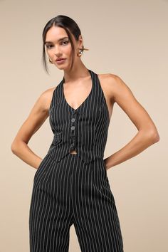 From the office to the after-work drink, the Lulus Pur-Suit of Chic Black and White Pinstripe Vest Top is the elevated look you need to beat the midweek blues! Midweight woven fabric shapes this on-trend top that has a V-neckline, an open halter-style back, and a functional button placket at the front. Decorative mini pocket adds a fun touch, and a smocked panel at back creates a perfect fit! Angled hems. Pair with the matching pants for a complete look! Fit: This garment fits true to size. Length: Size medium measures 17.5" from top to bottom. Bust: Great for any cup size. Waist: Fitted - elastic waist allows stretch. Undergarments: May be worn with a strapless bra, adhesive bra, petals, or no bra. Fabric: Fabric has no stretch. Lined. Shell: 91% Polyester, 9% Rayon. Lining: 97% Polyester Chic Striped Notch Lapel Suit, Chic Pinstripe Suits For Office, Chic Striped Suits For Office, Chic Striped Suits With Notch Lapel, Chic Pinstripe Suits With Notch Lapel, Spring Striped Fitted Suit, Spring Fitted Pinstripe Suits, Spring Pinstripe Fitted Suit, Pinstripe Vest