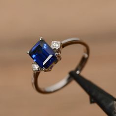 It is a lab sapphire ring. The main stone is a 6 mm*8mm emerald cut lab sapphire, weight about 1.50 carats. The basic metal is sterling silver and plated with rhodium. To change the metal to a solid gold (white/rose) or platinum is also available, please ask for a quotation if you want. You can also go to my shop Home for more elegant rings: https://www.etsy.com/shop/godjewelry?ref=hdr_shop_menu Sapphire is the birthstone of September. More sapphire rings: https://www.etsy.com/shop/godjewelry?re Classic Rectangular Lab-created Sapphire Ring, Elegant Octagon Sapphire Ring, Elegant 14k White Gold Emerald Cut Sapphire Ring, Emerald Cut Sapphire Ring Gift, Emerald Cut Sapphire Solitaire Promise Ring, Elegant Sapphire Ring With Emerald Cut, Emerald Cut Solitaire Sapphire Promise Ring, White Gold Solitaire Sapphire Ring, Emerald Cut, Elegant Sapphire Promise Ring With Rectangular Stone