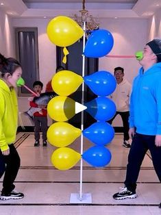 two people are standing in front of some balloons