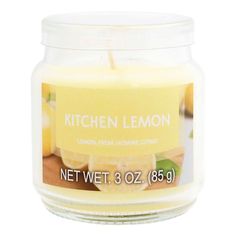 a glass jar filled with lemon and limeade scented candle next to a white background