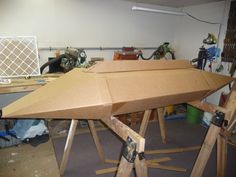 a large wooden object sitting on top of a piece of plywood in a garage