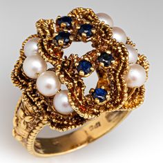 This elaborate vintage ring features an organic design and is four-prong set with six (6) round mixed cut sapphires. The top of the ring is accented with two (2) rows of four (4) cultured saltwater pearls, strung on gold wire. The ring measures 20.5mm at the top, rises 11.5mm above the finger, tapering to 3.6mm wide and 0.8mm thick at the base of the shank. The ring is currently a size 8.25 and shows a light patina. Vintage Multi-stone Pearl Ring For Anniversary, Vintage Multi-stone Pearl Ring For Formal Occasions, Vintage Multi-stone Pearl Ring For Formal Events, Heirloom Multi-stone Pearl Ring For Anniversary, Elegant Multi-stone Cluster Ring Collectible, Sapphire And Pearl, Pearl Cocktail Ring, Saltwater Pearls, Organic Design