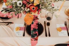 the table is set with flowers and place settings