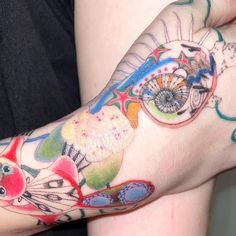 a woman's arm with colorful tattoos on it