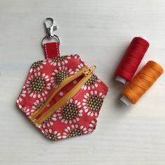 two spools of thread are next to a small purse