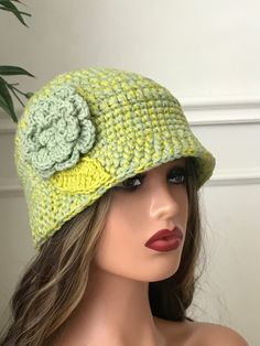 a mannequin head wearing a crocheted hat with a flower on it