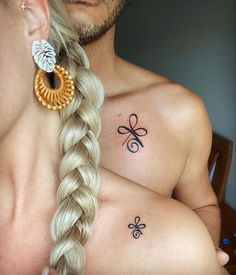 two people with tattoos on their chests and one has a flower in the middle