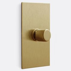 an image of a gold door handle on a white wall with a round knob in the middle