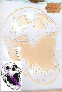 a close up of a stencil on a paper with a drawing of a skull