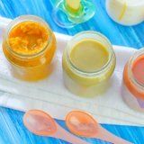 three jars filled with food sitting on top of a blue and white cloth next to spoons