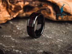 a black ring with red inlays and deer antlers on the inside of it