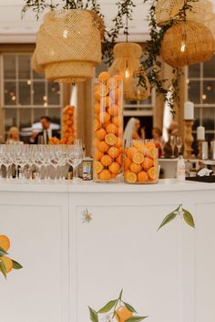 oranges are arranged on the bar in front of wine glasses and chandeliers