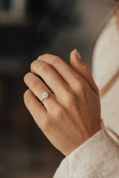 a woman's hand with a diamond ring on it