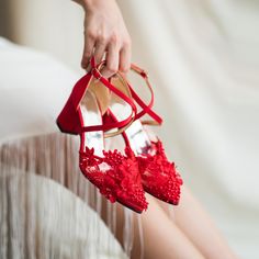 a woman's red high heeled shoes are being held up by her legs