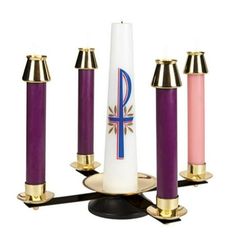 four candles are arranged in the shape of an obelisk with gold trimmings