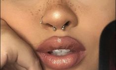 a woman with piercings on her nose and nose ring