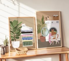 there are two framed pictures on the wall next to a table with a plant and a cat