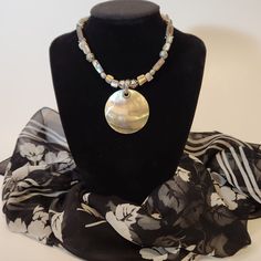 Introducing our stunning Abalone Pendant Necklace, a true embodiment of ocean elegance. This wonderful pendant glows like a beautiful sunset. This exquisite piece features a 2" diameter circle of luminescent abalone, accented with abalone beads and silver-toned bead and chain details. The adjustable length ranges from 18" to 20", ensuring a perfect fit for any occasion. Elevate your style with this unique, handcrafted necklace that captures the iridescence of the sea. In great pre-loved vintage Bohemian Iridescent Round Bead Jewelry, Bohemian Iridescent Beaded Jewelry, Bohemian Beaded Necklaces With Adjustable Pearl Pendant, Bohemian Beaded Necklace With Adjustable Pearl Pendant, Adjustable Bohemian Beaded Necklaces With Pearl Pendant, Spiritual Round Mother Of Pearl Necklace, Bohemian Shell Necklace With Pearl Pendant, Gold Bohemian Abalone Shell Necklace, Elegant Adjustable Abalone Shell Necklace