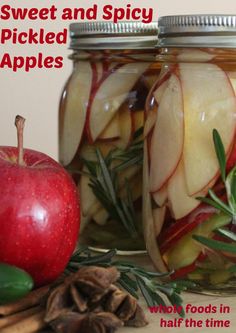 two jars filled with pickled apples next to an apple