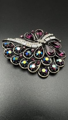 This vintage brooch pin features a unique leaf shape design adorned with sparkling purple rhinestones and Gun-Metal Silver colored metal. The piece has been signed by Albert Weiss, adding a touch of history and authenticity to its collection. Measures at 2.5"x2" (210) Purple Rhinestone, Rhinestone Brooches, Vintage Brooch, Leaf Shapes, Jewelry Lover, Shape Design, Vintage Brooches, Vintage Signs, Vintage Watches