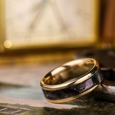 two wedding rings sitting on top of a table next to an old pocket watch face