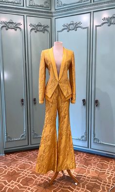 This silk blazer pantsuit is from Wes Gordon's Fall 2003 Runway. The color is a stunning canary yellow with a silver lurex brocade design all through out. The blazer includes a double layer made of yellow silk satin and a high waist flared pant leg. Truly Magnificent. Wes Gordon interned with Oscar De La Renta and Tom Ford after graduating from Central St. Martins in 2009, the same year he launched his own self named line of women's wear. In 2018, he took over at Carolina Herrera as creative director. Blazer and Pant size: 6 Brocade Blazer Women, Gold Festive Evening Suit, Yellow Long Sleeve Blazer For Party, Long Sleeve Yellow Blazer For Party, Gold Fitted Suits For Spring, Yellow Notch Lapel Elegant Suit, Yellow Fitted Elegant Blazer, Elegant Yellow Pantsuit For Formal Occasions, Fitted Elegant Yellow Blazer