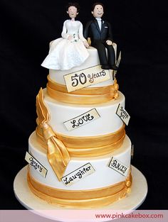 a wedding cake with two people sitting on top of it and the words 50 years