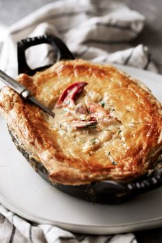 a close up of a pie on a plate with a pair of scissors in it