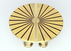 two brass plated objects on white surface with brown lines in the middle and bottom