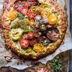 an overhead view of a pizza with tomatoes, zucchini and other toppings