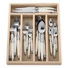 an assortment of utensils and spoons in a wooden box