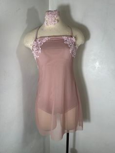 a mannequin wearing a pink top with flowers on it's neckline