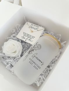 an open box containing a personalized bottle, necklace and card with a flower on it