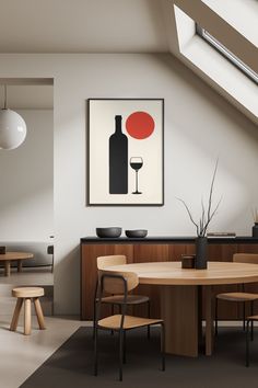 a dining room table with chairs and a wine bottle on the wall next to it