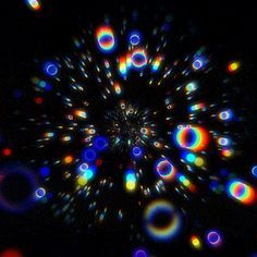 an image of colorful lights in the dark with circles on it's center and black background