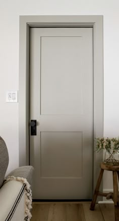 a white door in a living room next to a chair