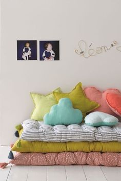 a bed that has pillows on it and some pictures above the headboard behind it