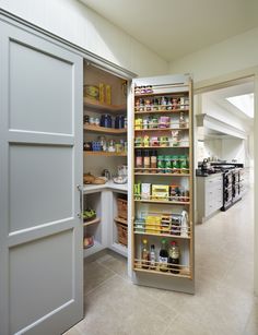 an open pantry door in a kitchen with shelves full of food and condiments