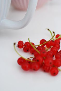 some red berries sitting on top of a white table