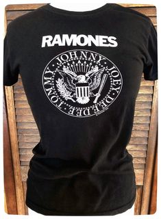 "Super cool Vintage RAMONES T Shirt in Black Ladies XS/Small. This Rock Merch tee from the classic American Punk Band is a must have for fan and / or collector! The art work designed by Arturo Vega has original \"Look out below\" which was only seen in earlier designs then switched to \"hey hey let's go\" and even later \"blizkrieg Bop\"   Most likely a reprint from the 90s or 2000s but still a very rare and hard to find shirt.  Good preloved condition. This shirt is super soft, slight fading and pilling from normal well loved wear and washing. No Stains. No Holes.  Brand: Ramones 1-2-3-4 Size: Ladies Small (slim fit)  Pit to Pit 18\" Centre Back to Hem 23 1/4\" 100% Cotton all shipping has is insurances and tracked. *all international sales may be subject to duties and/or taxes when  ente Fitted Punk T-shirt With Letter Print, Rock Style Band Logo T-shirt With Crew Neck, Rock Style Crew Neck T-shirt With Screen Print, Punk Style Fitted Graphic T-shirt, Rock Style Cotton T-shirt With Logo Print, Fitted Punk T-shirt For Concert, Punk Style Fitted T-shirt For Concerts, Edgy Band Logo T-shirt For Music Festivals, Punk T-shirt With Front Print For Concert