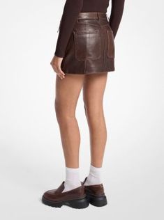 This moto-inspired skirt is made from supple leather with a faded finish that lends it a vintage touch. Slant pockets and tonal stitching add to its biker feel. Counter the mini length with combat boots. Mini Leather Skirt Outfit, Brown Leather Skirt, Faux Leather Mini Skirt, Leather Mini Skirt, Skirt Leather, Michael Kors Collection, Leather Mini Skirts, Colby, Denim Mini Skirt