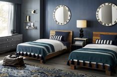 two beds in a bedroom with blue walls