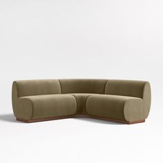 a large sectional couch sitting on top of a white floor next to a wooden frame