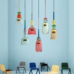 several different colored chairs and lights hanging from the ceiling in a room with blue walls