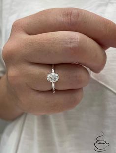 a woman's hand with a diamond ring on it