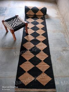 a black and white rug sitting on top of a floor next to a wooden chair