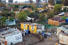 an aerial view of some shacks in a rural area with trees and bushes around them